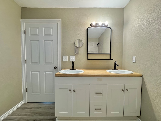919 E 20th St, San Angelo, TX 76903 - bathroom with wood finished floors, double vanity, and baseboards