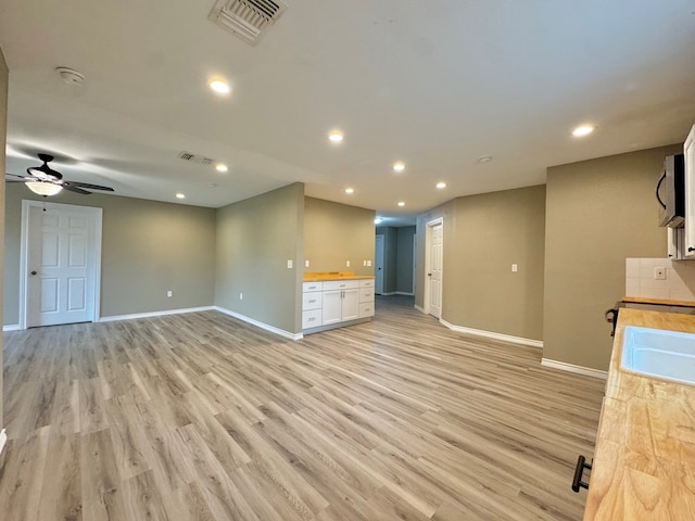 919 E 20th St, San Angelo, TX 76903 - unfurnished living room with baseboards, light wood-style floors, recessed lighting, ceiling fan, and a sink