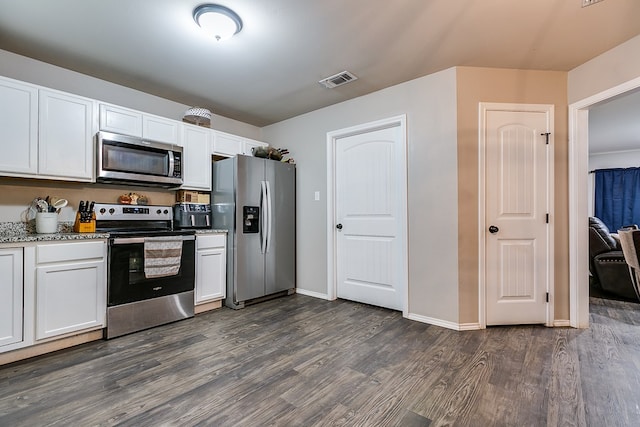 kitchen featuring white cabinetry, light stone countertops, dark wood-type flooring, and stainless steel appliances