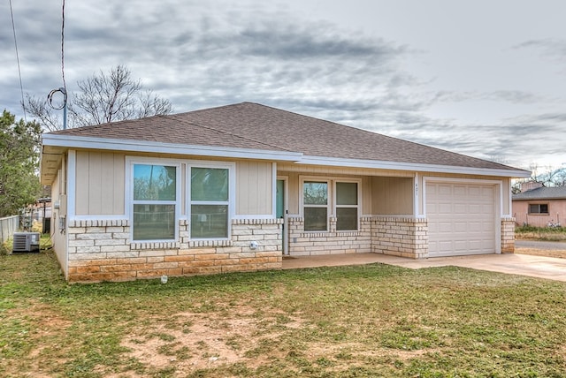 single story home featuring a garage, a front lawn, and central air condition unit