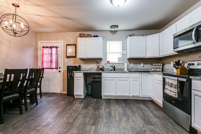 kitchen featuring pendant lighting, dark wood-type flooring, appliances with stainless steel finishes, light stone counters, and white cabinets