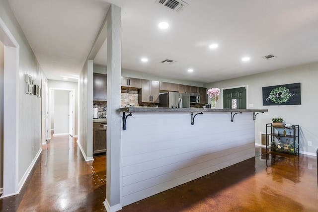 kitchen featuring stainless steel appliances, a breakfast bar area, and kitchen peninsula