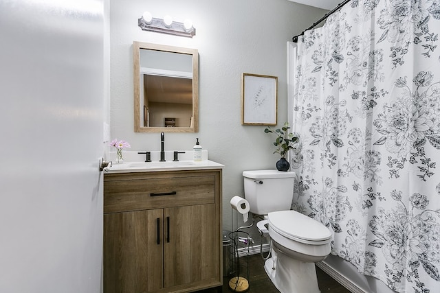 bathroom featuring walk in shower, vanity, and toilet