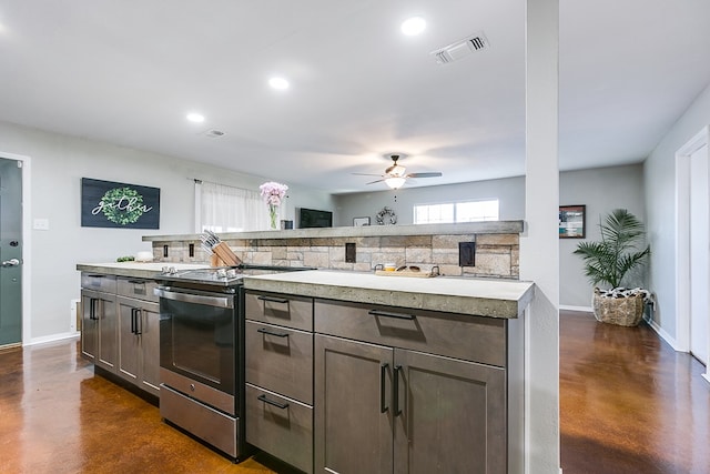 kitchen with ceiling fan, dark brown cabinets, a center island, and stainless steel electric range