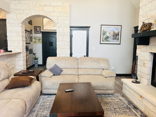 living room with hardwood / wood-style flooring, a fireplace, and vaulted ceiling