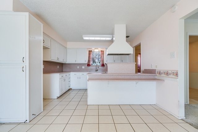 261 Edinburgh Rd, San Angelo, TX 76901 - kitchen featuring light countertops, a peninsula, a sink, and island exhaust hood
