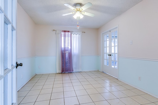 261 Edinburgh Rd, San Angelo, TX 76901 - empty room featuring light tile patterned flooring, a textured ceiling, french doors, and a ceiling fan