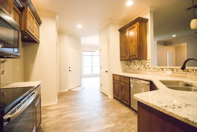 5806 Willeke Dr, San Angelo, TX 76904 - kitchen featuring stainless steel appliances, a sink, crown molding, light stone countertops, and brown cabinets
