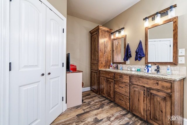 3504 Badger Ct, San Angelo, TX 76901 - full bath with double vanity, wood finished floors, baseboards, and a closet