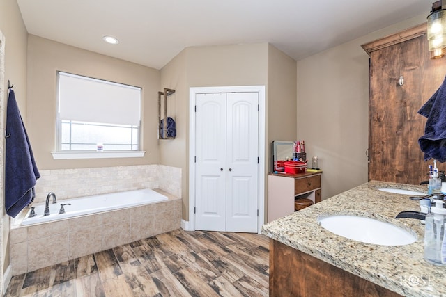 3504 Badger Ct, San Angelo, TX 76901 - full bathroom featuring a closet, a garden tub, double vanity, wood finished floors, and recessed lighting
