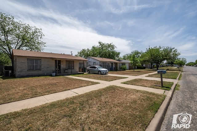 ranch-style home with a front yard and central air condition unit