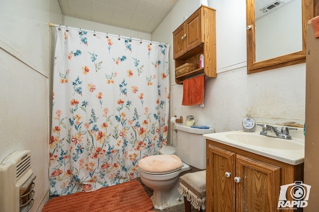 bathroom with vanity, heating unit, and toilet