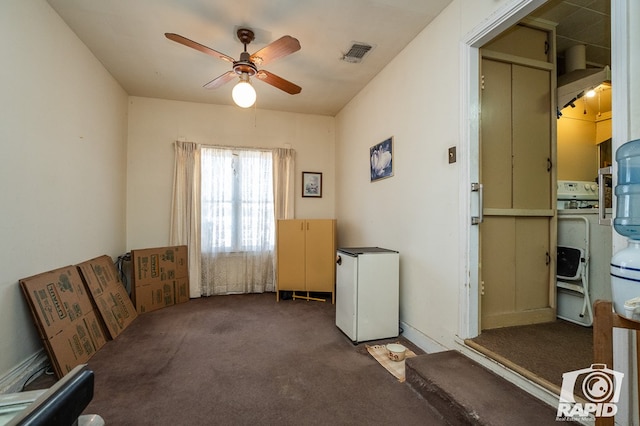 miscellaneous room featuring ceiling fan, washer / dryer, and dark carpet