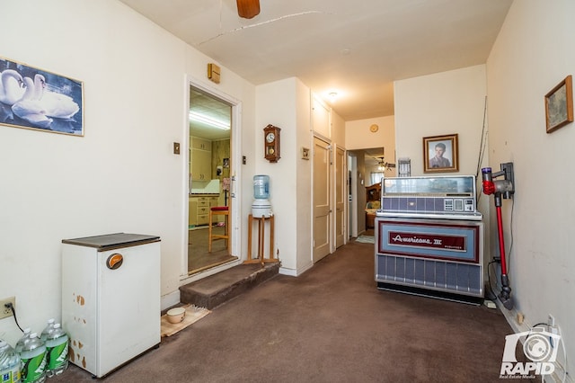 misc room with ceiling fan and dark colored carpet