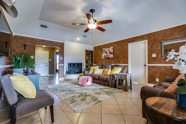 tiled living room featuring lofted ceiling, ceiling fan, ornamental molding, and a textured ceiling