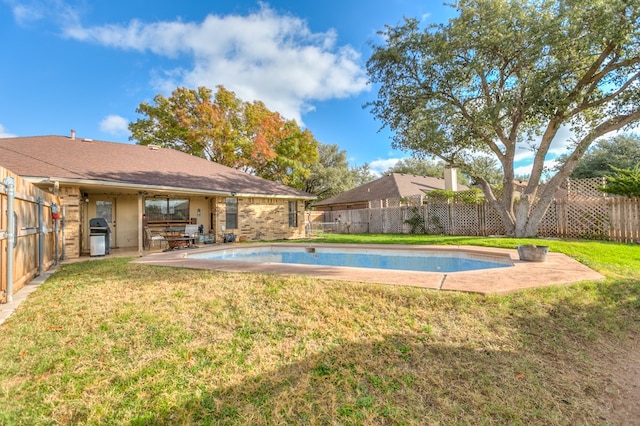 view of swimming pool with area for grilling, a patio area, and a lawn