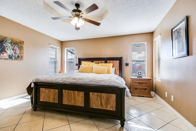 tiled bedroom featuring ceiling fan and a textured ceiling