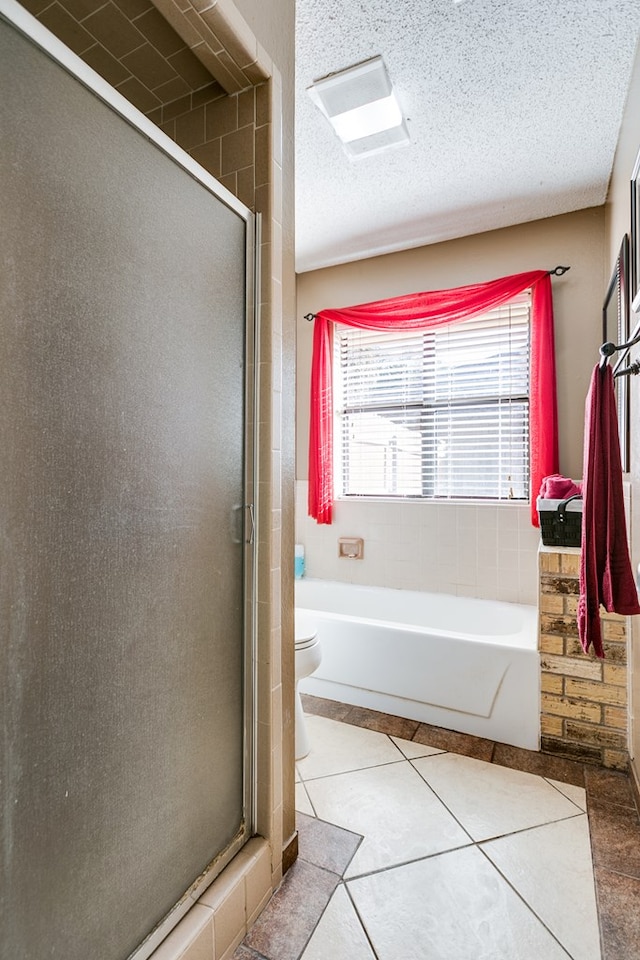 bathroom featuring tile patterned flooring, a textured ceiling, toilet, and separate shower and tub