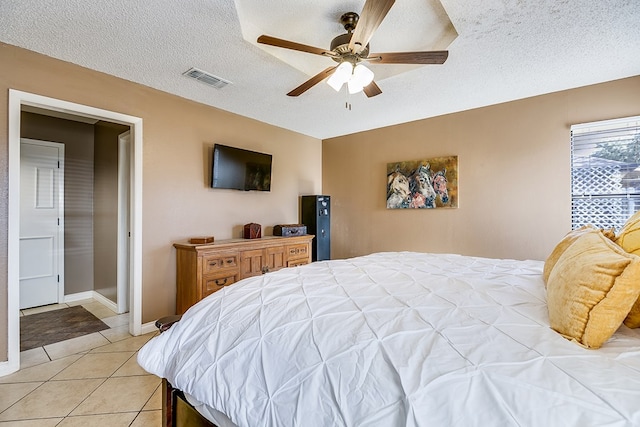 bedroom with light tile patterned floors, a textured ceiling, and ceiling fan