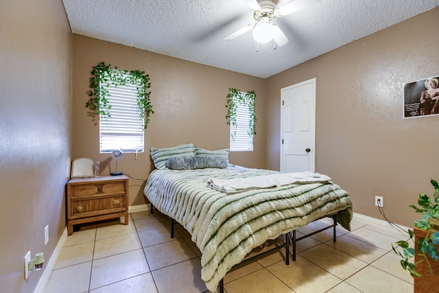 tiled bedroom featuring ceiling fan and a textured ceiling