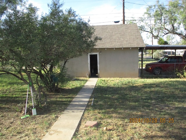 exterior space featuring a carport and a yard