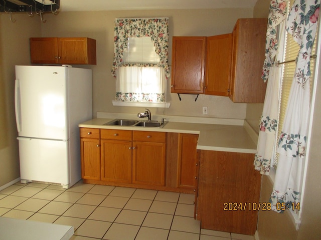 kitchen with sink, light tile patterned floors, and white refrigerator