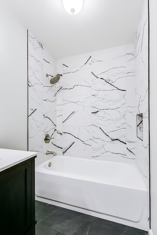 bathroom featuring vanity, tiled shower / bath combo, and tile patterned flooring