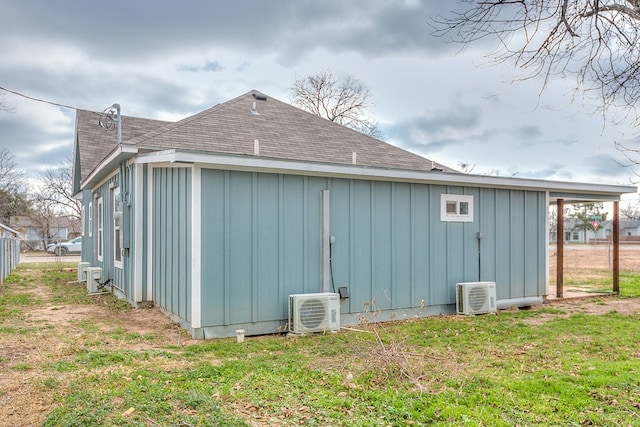 view of side of home with a lawn and ac unit