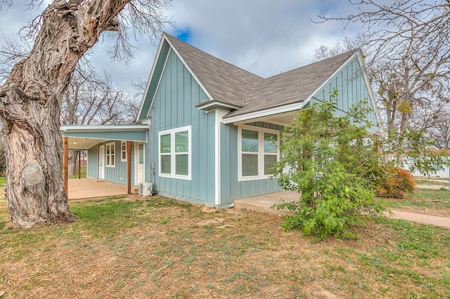 view of side of home with covered porch and a lawn