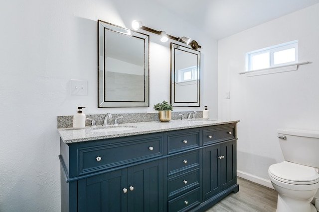 bathroom featuring vanity, wood-type flooring, and toilet