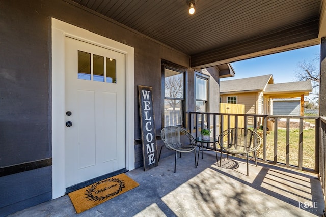 doorway to property with covered porch and stucco siding