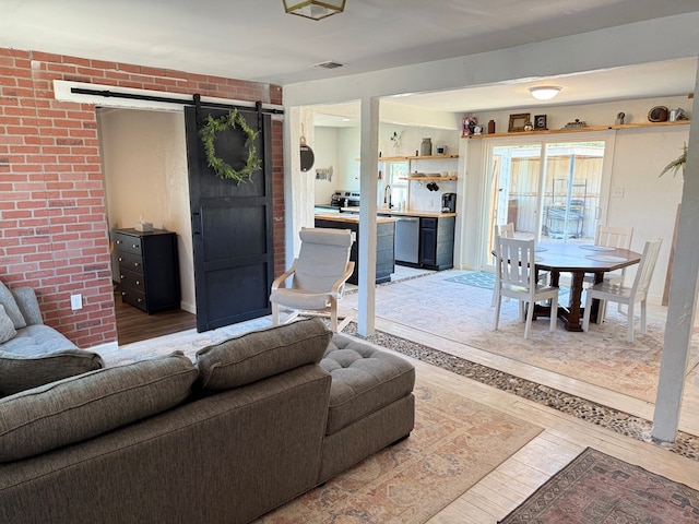 1702 Ellis St, San Angelo, TX 76905 - living area featuring a barn door, hardwood / wood-style flooring, and brick wall
