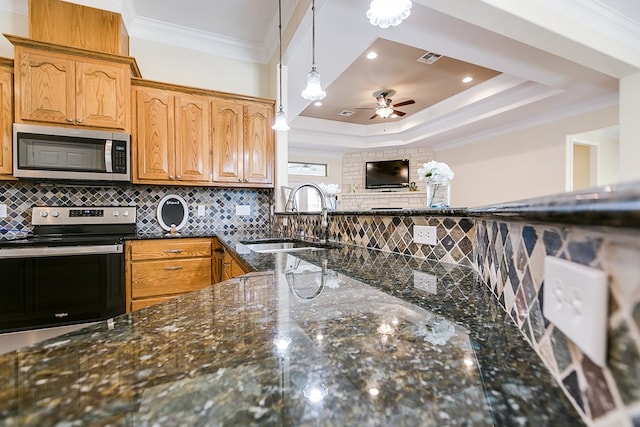 kitchen with sink, crown molding, hanging light fixtures, dark stone countertops, and appliances with stainless steel finishes