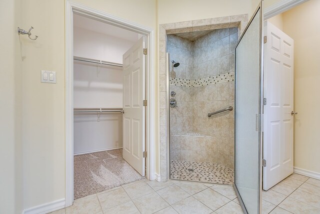 bathroom featuring tile patterned flooring and tiled shower