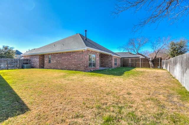 rear view of property with a yard and central air condition unit