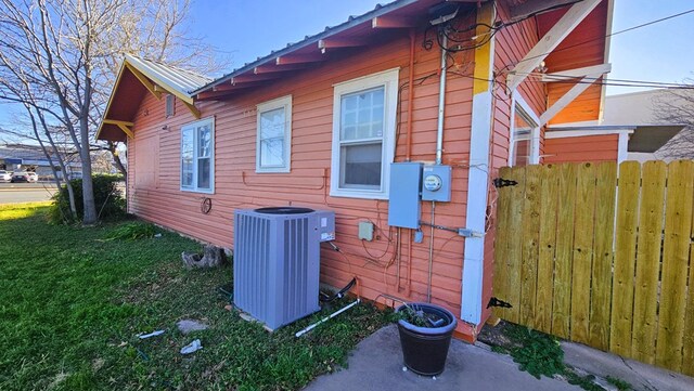 view of side of home with a yard and central AC unit