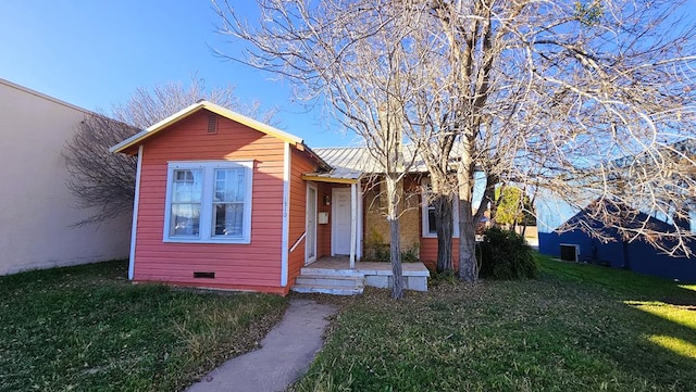 view of front of home featuring cooling unit and a front lawn