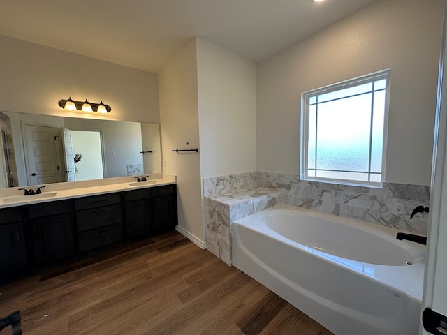 bathroom featuring wood-type flooring, a bathing tub, and vanity