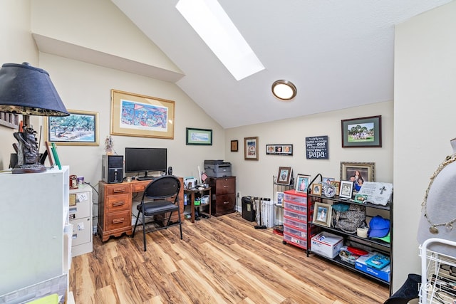 home office with light wood finished floors and lofted ceiling with skylight