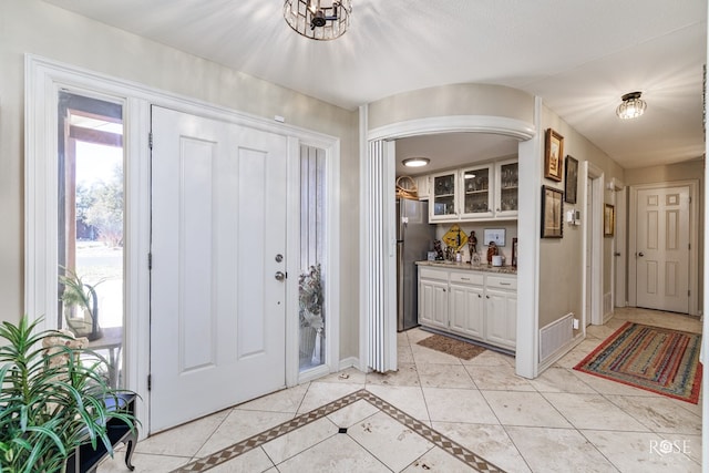 foyer with visible vents, baseboards, and light tile patterned floors