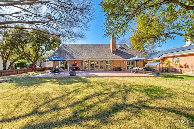 back of house featuring french doors, a patio, fence, a yard, and an outdoor structure