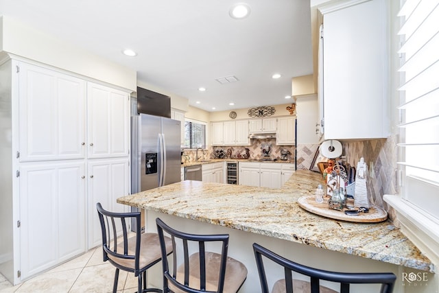 kitchen with wine cooler, stainless steel appliances, a peninsula, visible vents, and tasteful backsplash