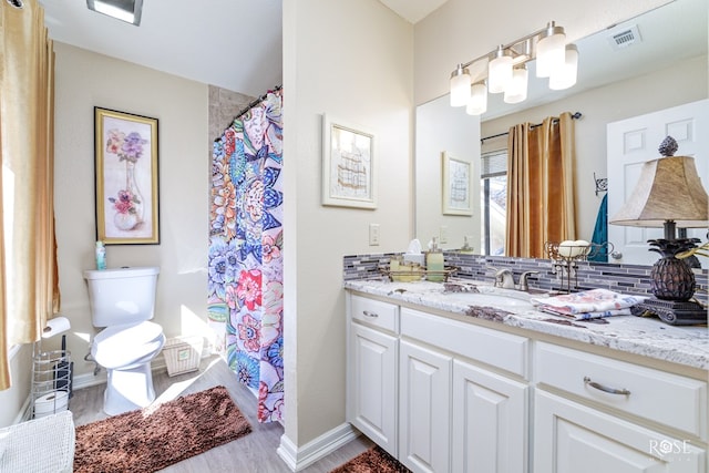 full bath featuring curtained shower, toilet, visible vents, vanity, and decorative backsplash