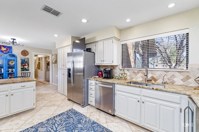 kitchen featuring appliances with stainless steel finishes, a sink, visible vents, and white cabinetry