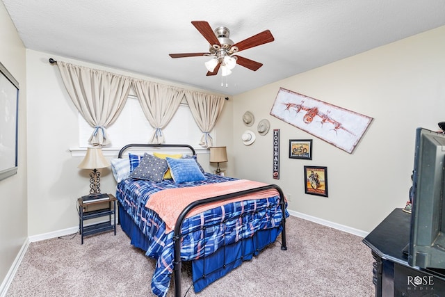 carpeted bedroom with a ceiling fan, a textured ceiling, and baseboards