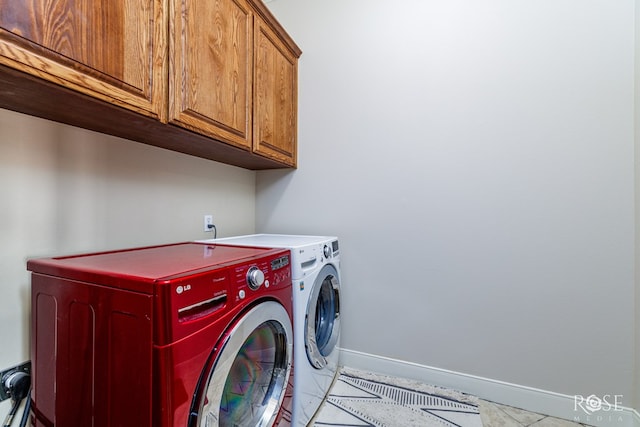 laundry room featuring washing machine and clothes dryer, cabinet space, and baseboards