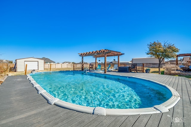 view of swimming pool featuring a fenced in pool, a wooden deck, a fenced backyard, an outdoor structure, and a pergola