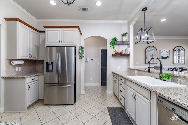 kitchen with visible vents, ornamental molding, a sink, arched walkways, and appliances with stainless steel finishes