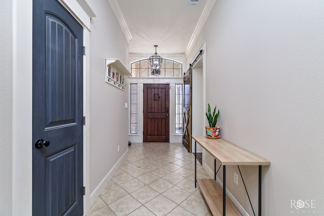 entrance foyer featuring ornamental molding, a barn door, an inviting chandelier, light tile patterned floors, and baseboards