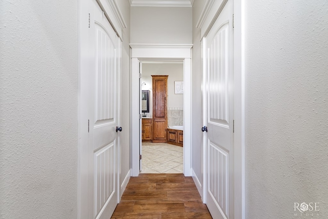 hall with crown molding, dark wood-type flooring, and a textured wall